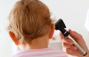 Nell'orecchio di un bambino è inserito un otoscopio per un controllo medico
